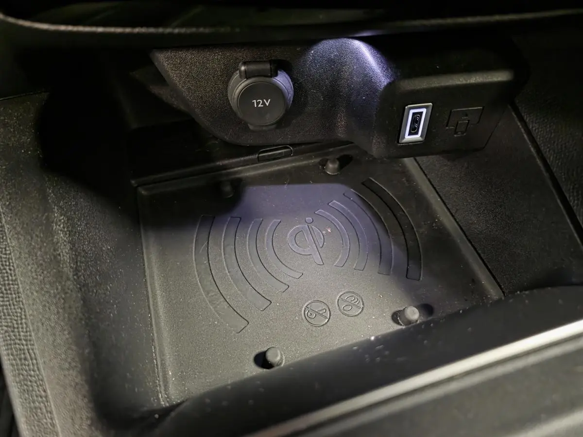 Gros plan sur le chargeur smartphone par induction et prise USB dans la console centrale d’un Opel Mokka-e noir.