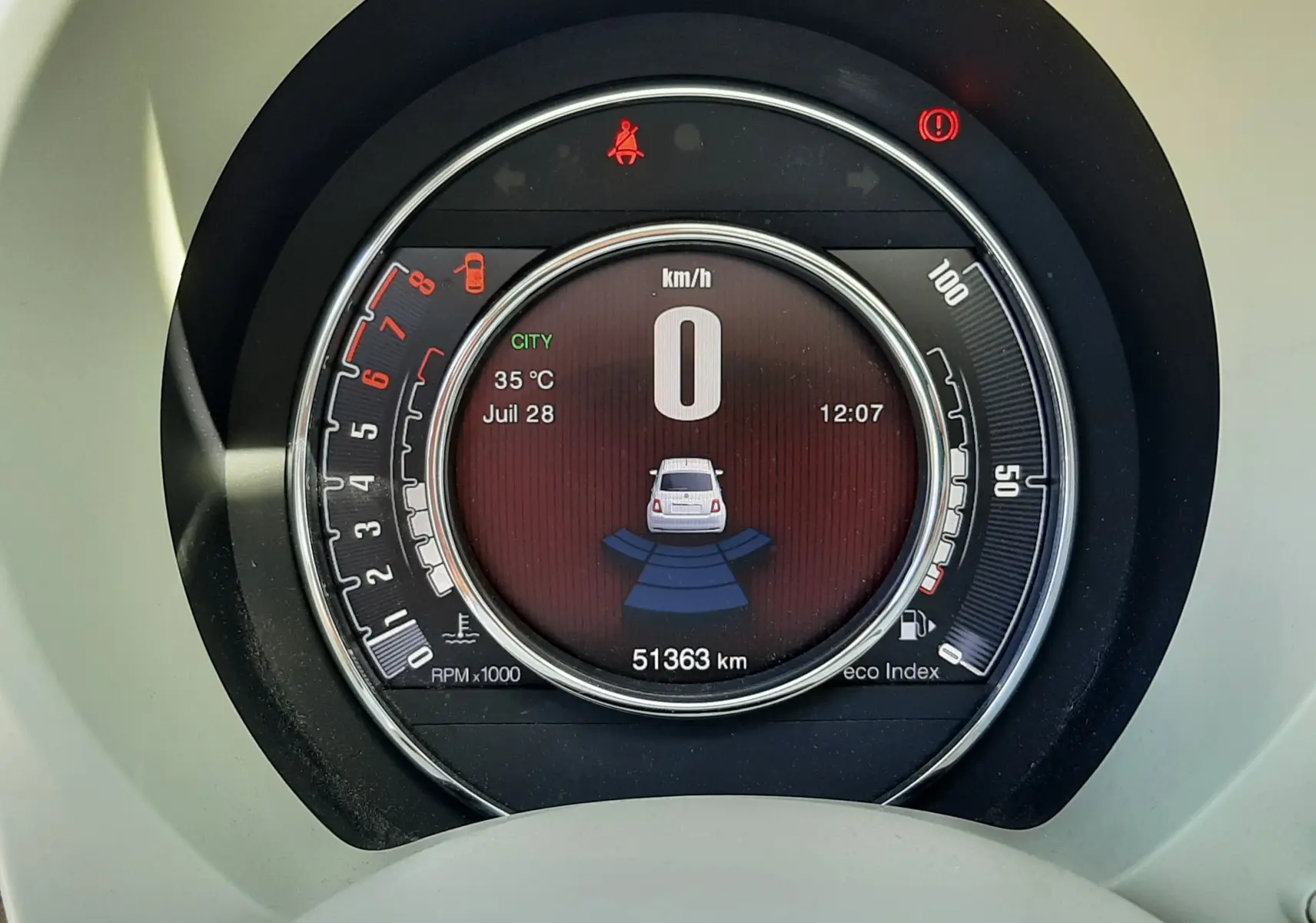 Vue rapprochée du tableau de bord numérique de la Fiat 500 bleu, affichant la vitesse à 0 km/h et l'odomètre à 51363 km.