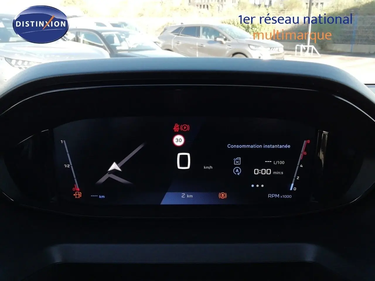 Vue rapprochée du tableau de bord numérique du Peugeot Partner blanc Kaolin 2026, affichant la consommation instantanée et le compteur.