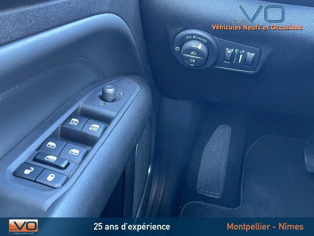 Vue rapprochée du panneau de commandes côté conducteur du Jeep Compass blanc 2024 avec réglages électriques et commandes d’éclairage.