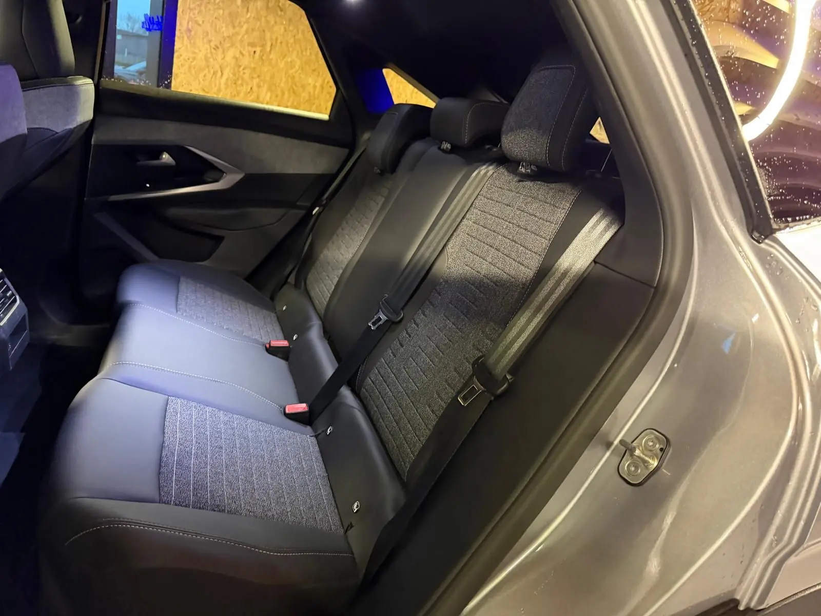 Vue intérieure côté droit des sièges arrière en tissu gris et noir du Peugeot 3008 1.2 HYBRID 136 ALLURE 2025 gris.