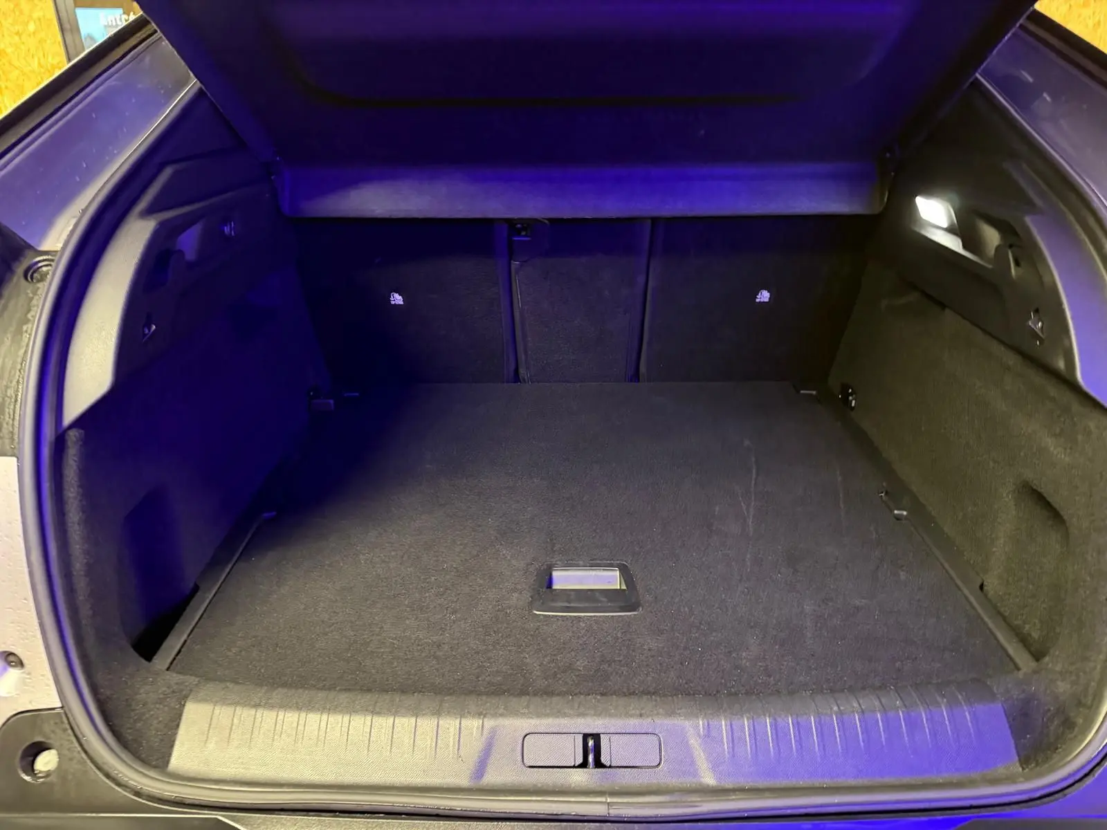 Coffre ouvert du Peugeot 3008 gris 2025, vue arrière montrant un espace de chargement propre et éclairé.