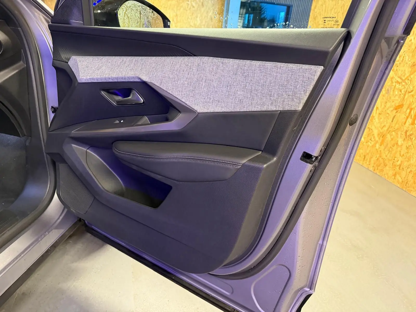 Vue rapprochée de la porte avant gauche gris métallisé du Peugeot 3008 1.2 Hybrid 136 Allure avec habillage tissu et cuir noir.