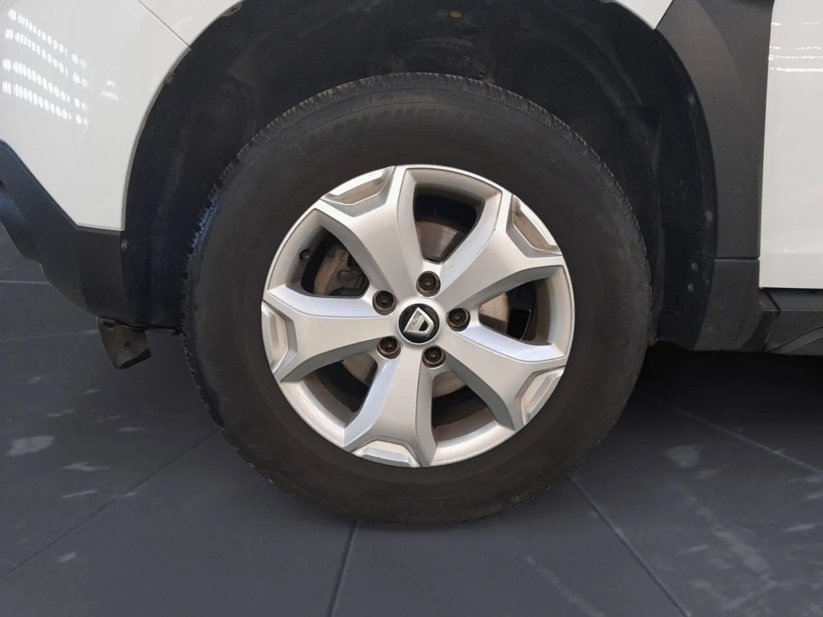 Vue intérieure côté conducteur du tableau de bord noir et volant du Dacia Duster blanc 2021, version diesel 4x2.