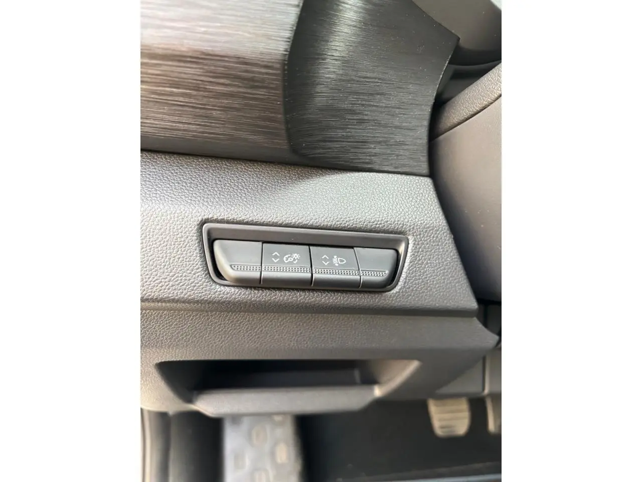 Détail des commandes d’éclairage sur le tableau de bord côté gauche du Renault Trafic Fourgon gris clair 2022.