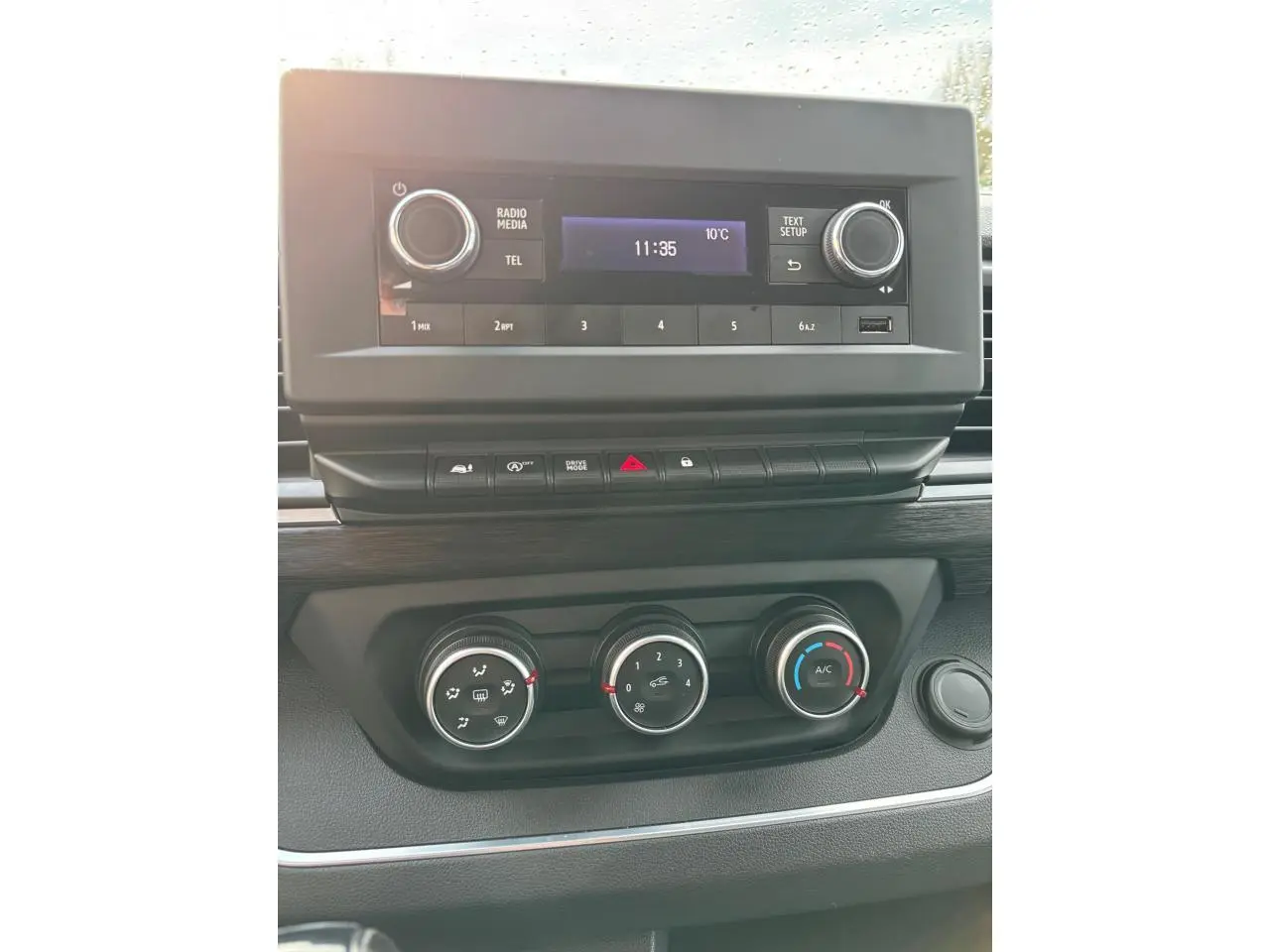 Vue rapprochée du tableau de bord du Renault Trafic Fourgon 2022 avec commandes climatisation et écran radio noir.