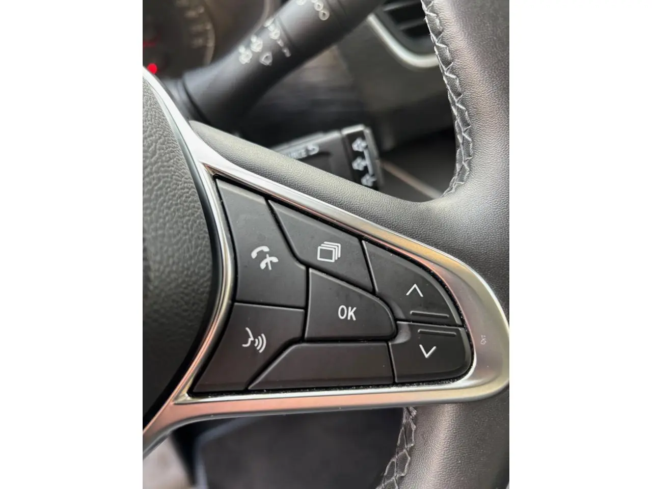 Gros plan sur les commandes multifonctions noires du volant du Renault Trafic Fourgon gris clair, finition 2022.