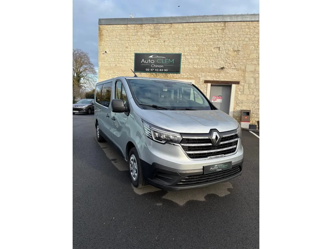 Renault Trafic Fourgon gris clair vu en 3/4 avant droit, avec calandre noire et phares LED distinctifs.