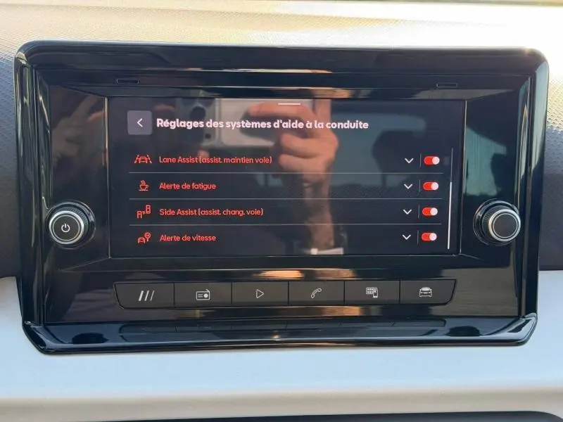 Écran tactile central du SEAT Arona 2025 affichant les réglages d'aides à la conduite avec interface noire brillante.