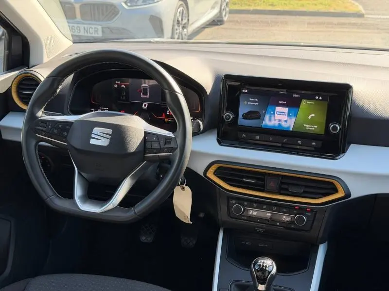 Vue intérieure du poste de conduite du SEAT Arona 2025 avec volant cuir multifonction et écran tactile central.