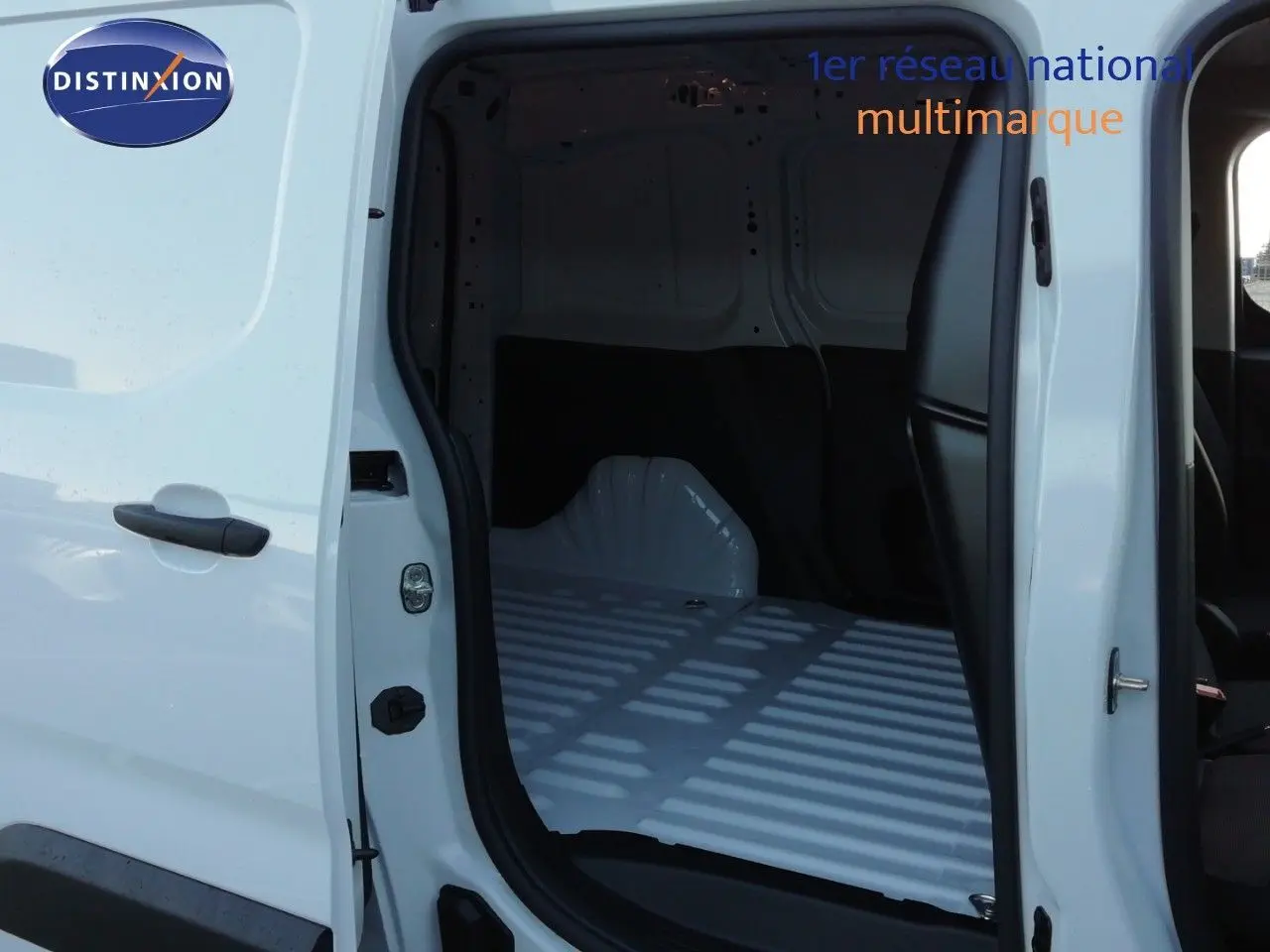 Vue latérale gauche du Peugeot Partner blanc Kaolin 2026 avec porte coulissante ouverte montrant l’espace de chargement vide.
