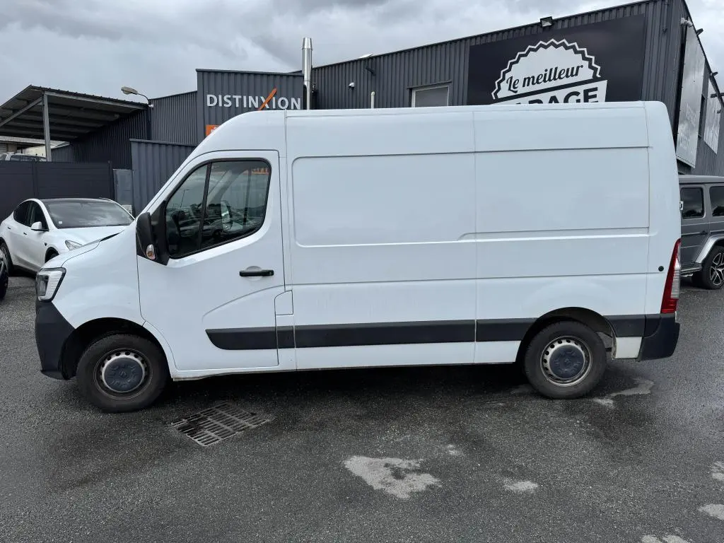 Profil côté gauche d'un utilitaire Renault Master blanc avec baguettes noires et roues tôlées 16 pouces, stationné en extérieur.