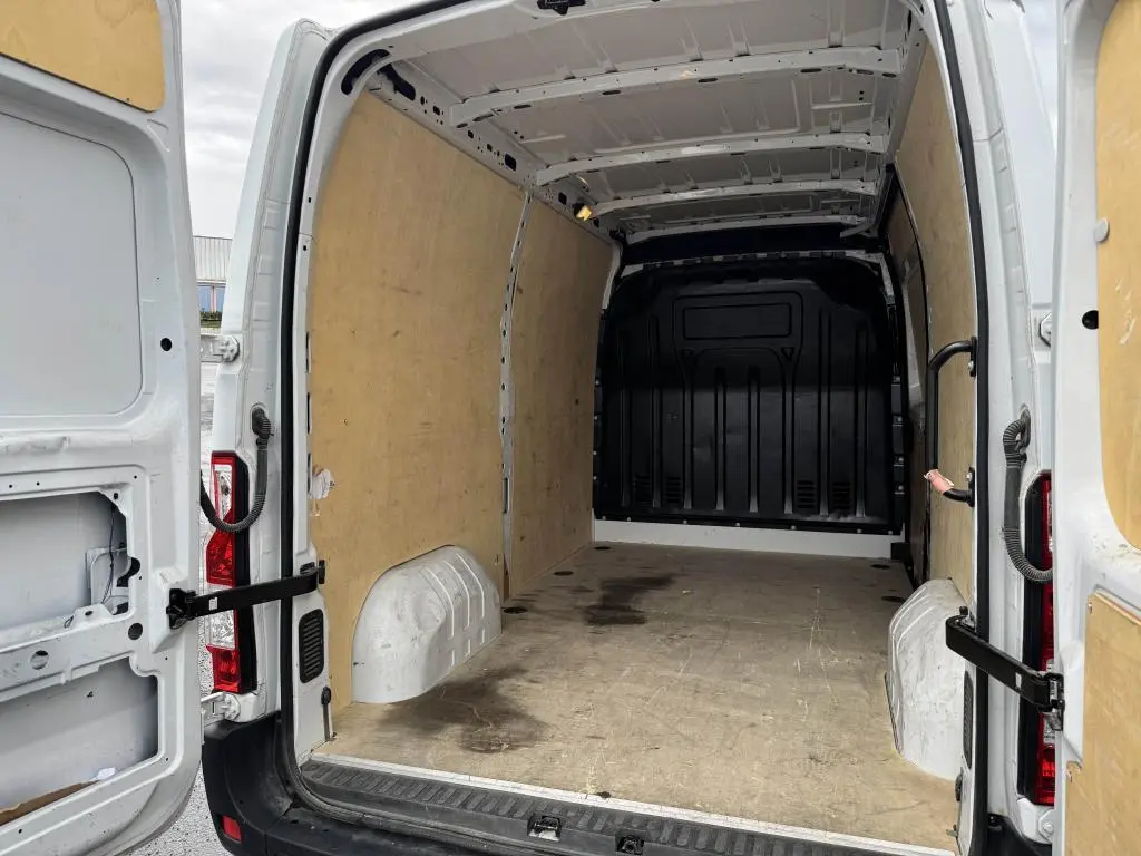 Vue arrière du Renault Master blanc 2022, montrant l'espace de chargement avec habillage bois et portes arrière ouvertes.