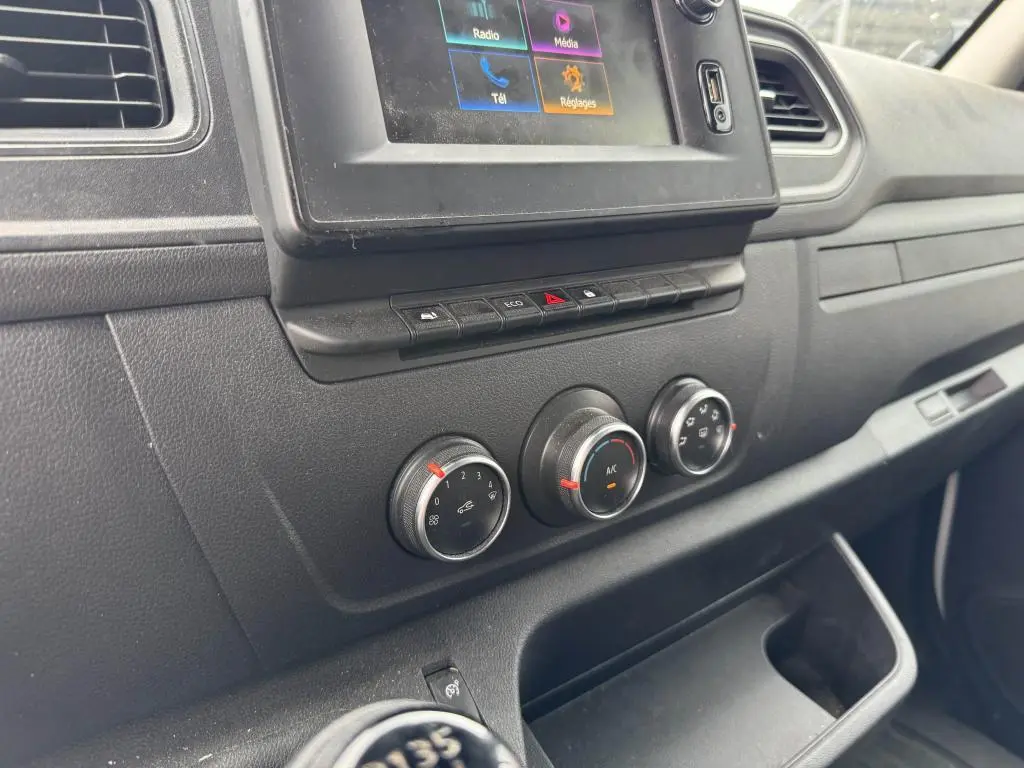 Tableau de bord noir du Renault Master 2022, vue rapprochée sur commandes climatisation et écran tactile central.