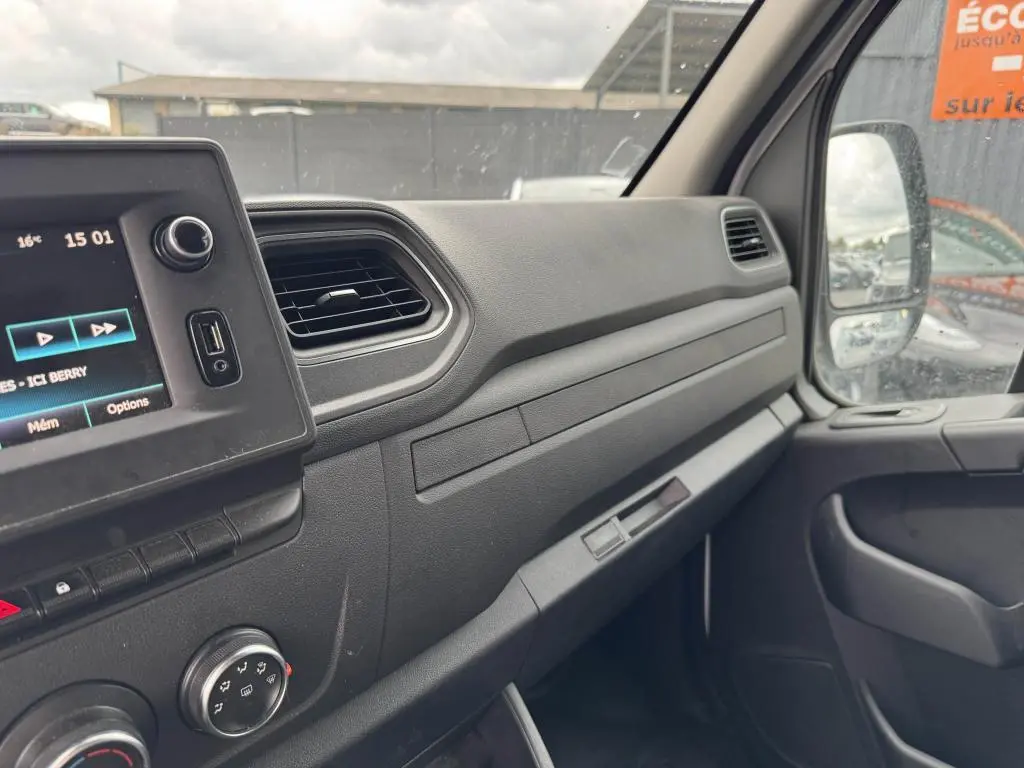 Tableau de bord côté passager du Renault Master blanc 2022 avec écran tactile et commandes climatisation visibles.