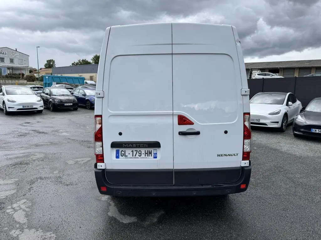 Vue arrière d'un Renault Master blanc avec portes arrière tôlées et plaque d'immatriculation française visible.