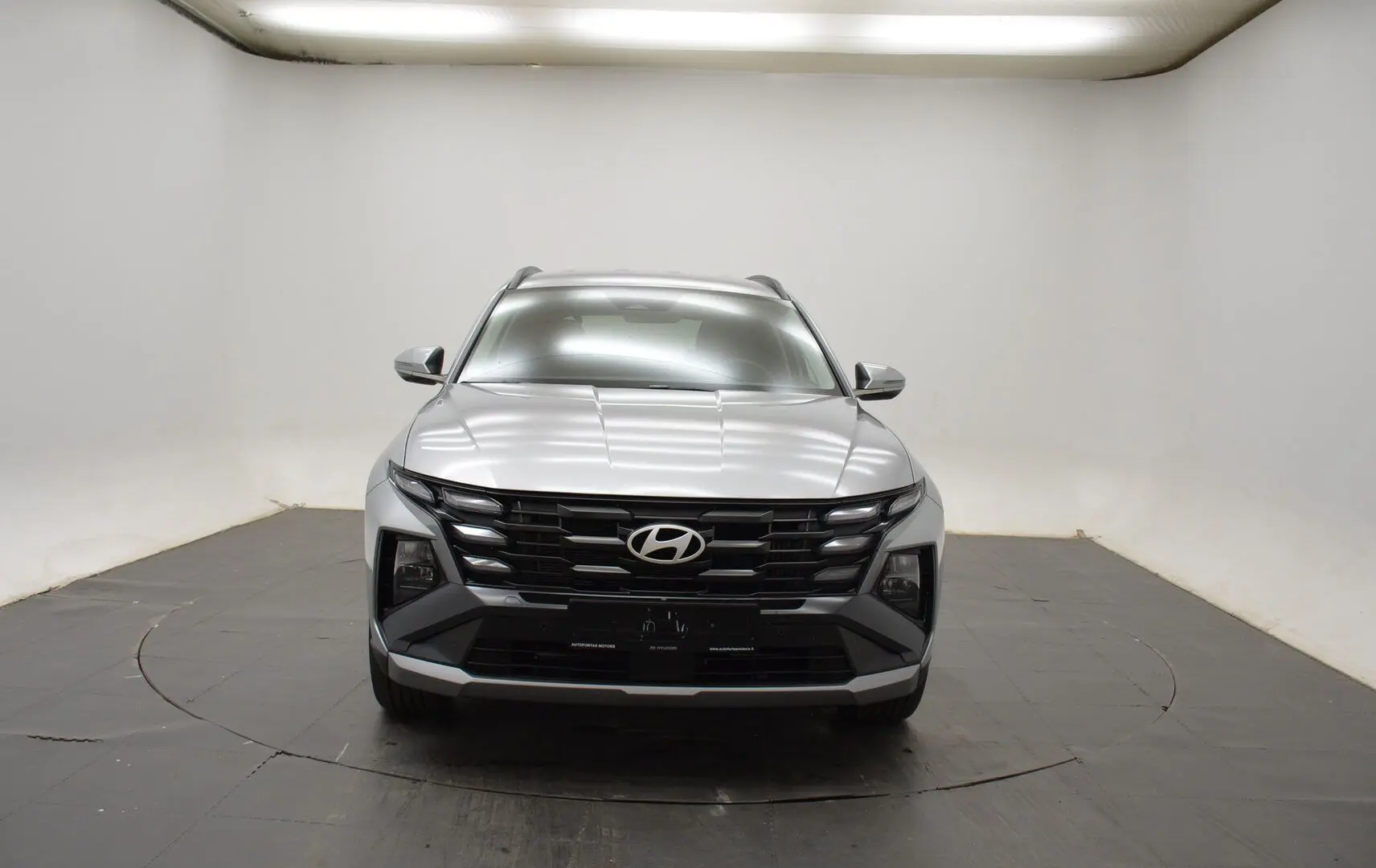 Hyundai Tucson 2025 Shimmering Silver en 3/4 avant droit, avec jantes 18 pouces et calandre noire distinctive.