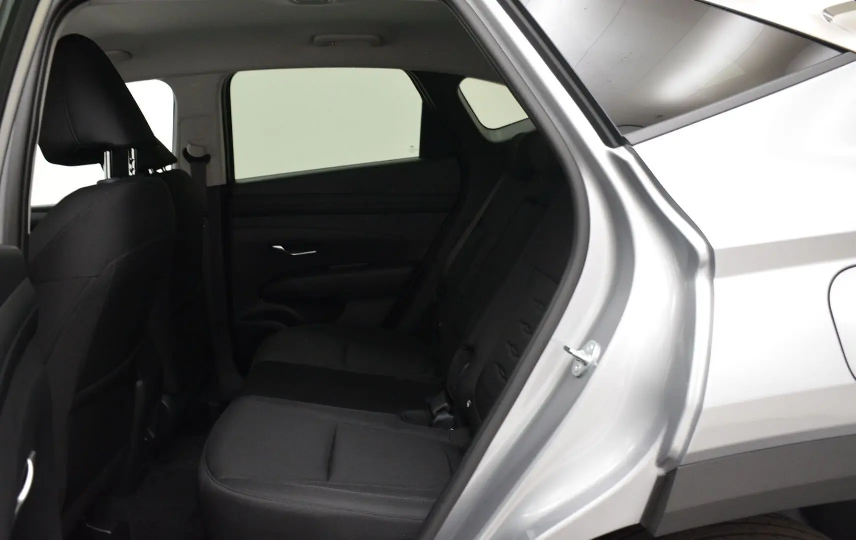 Vue intérieure côté droit sur la banquette arrière noire du Hyundai Tucson 2025 en Shimmering Silver.