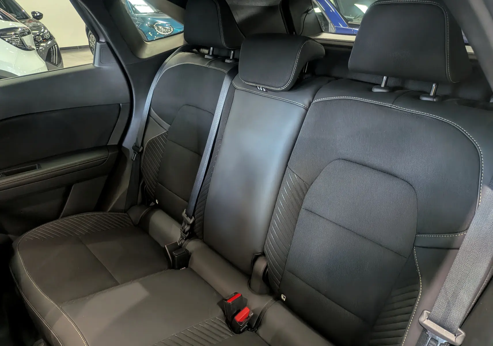 Vue intérieure de la banquette arrière en cuir noir avec surpiqûres blanches du Renault Symbioz E-TECH 2025.