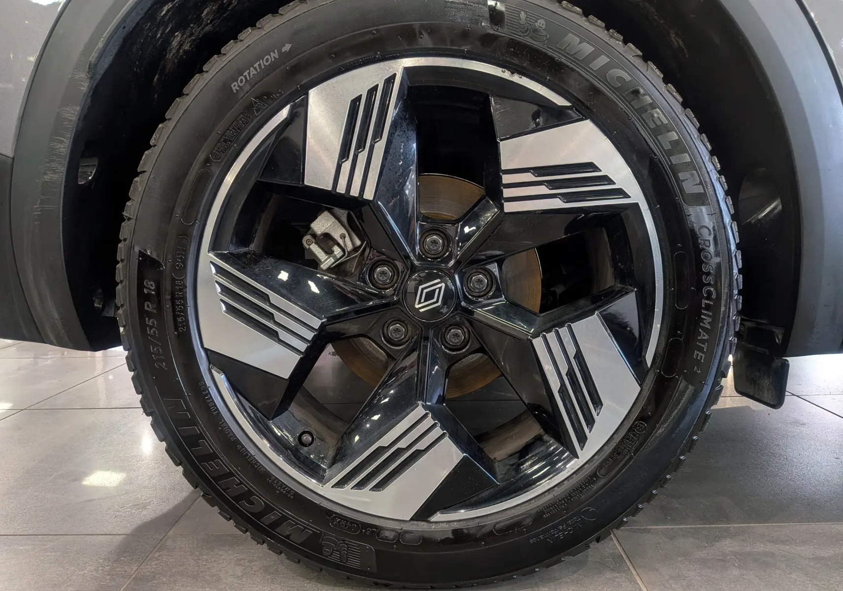 Gros plan sur la jante bi-ton noir et argent avec logo Renault, montée sur un pneu Michelin CrossClimate.
