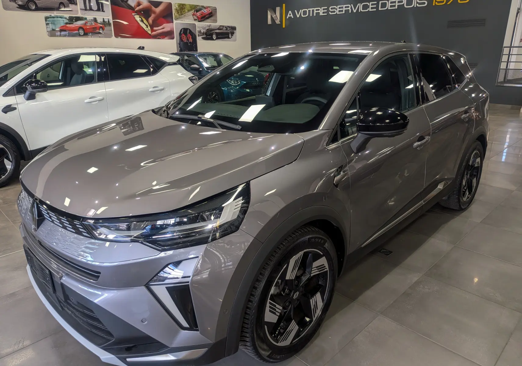 Vue 3/4 avant droite du Renault SYMBIOZ E-TECH gris Cassiopé, mettant en valeur ses optiques LED et jantes bicolores.