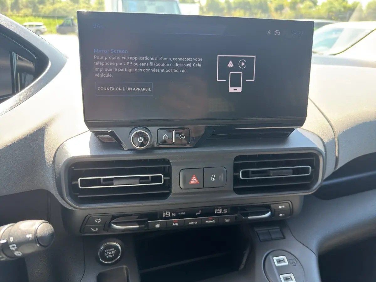 Vue rapprochée de la console centrale du Peugeot Rifter 2026 avec écran tactile, commandes climatisation et bouton start/stop.