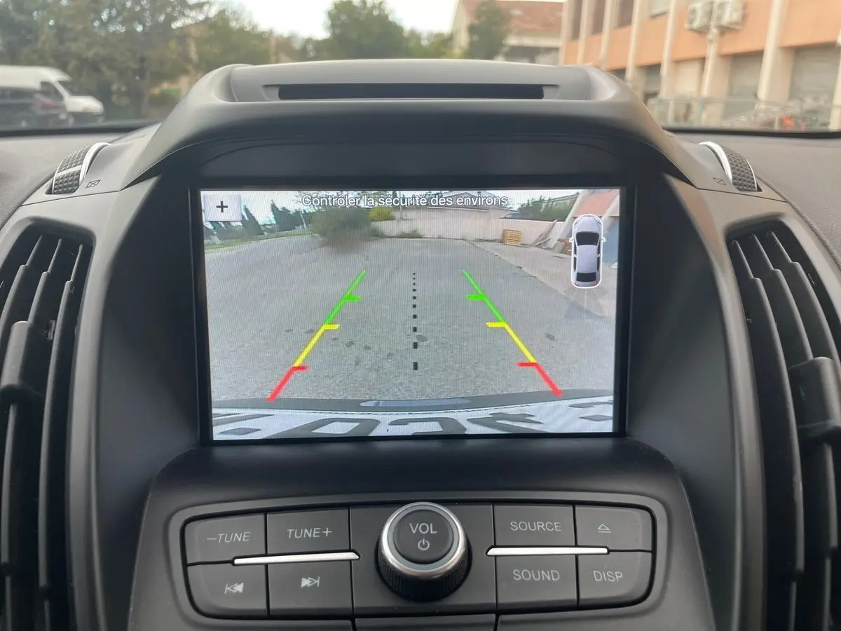 Écran de caméra de recul du Ford Kuga gris 2017, vue intérieure centrée sur le tableau de bord et les commandes audio.