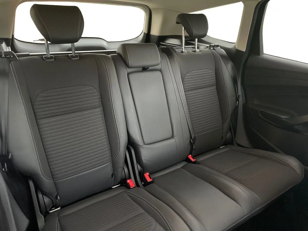 Vue intérieure arrière des sièges en cuir noir du Ford Kuga 2017, avec appuie-têtes et ceintures visibles.