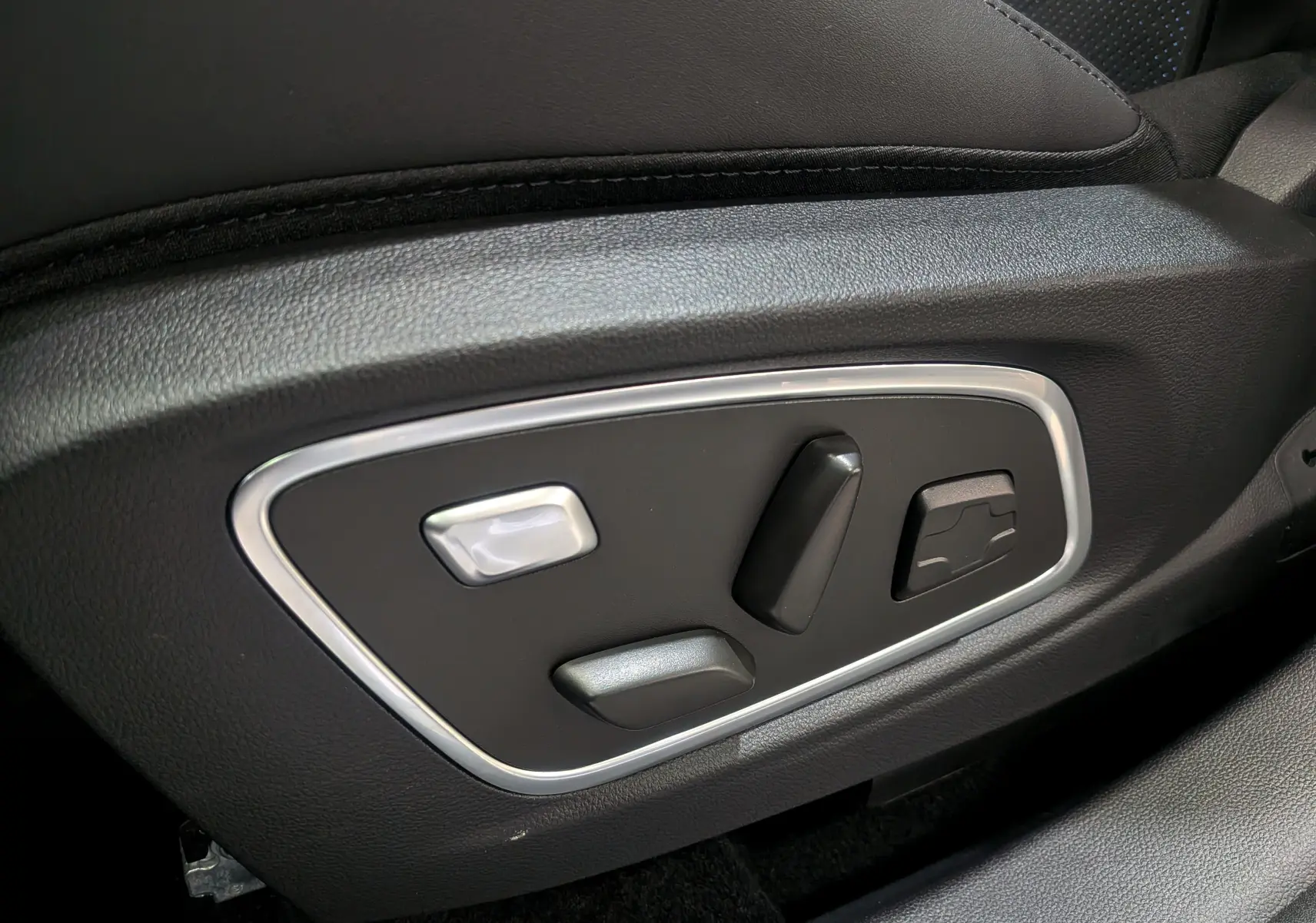 Gros plan sur les commandes électriques de réglage du siège en cuir noir du Renault Rafale E-TECH 2025.