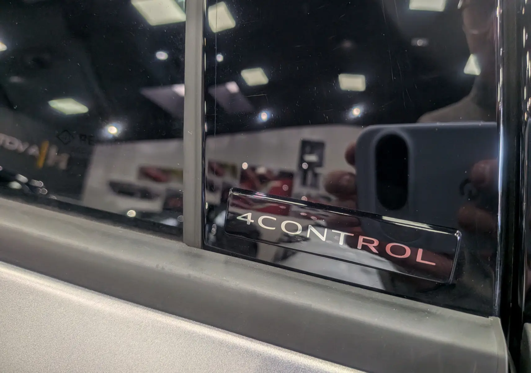 Gros plan sur l’inscription 4CONTROL sur la porte côté gauche d’une Renault Rafale gris schiste satin.