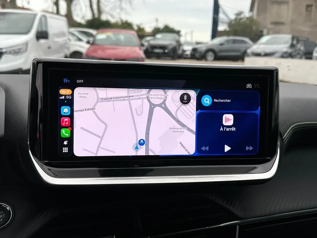 Écran tactile du tableau de bord du Peugeot 208 Hybrid 110 gris, affichant la navigation et les commandes multimédia.