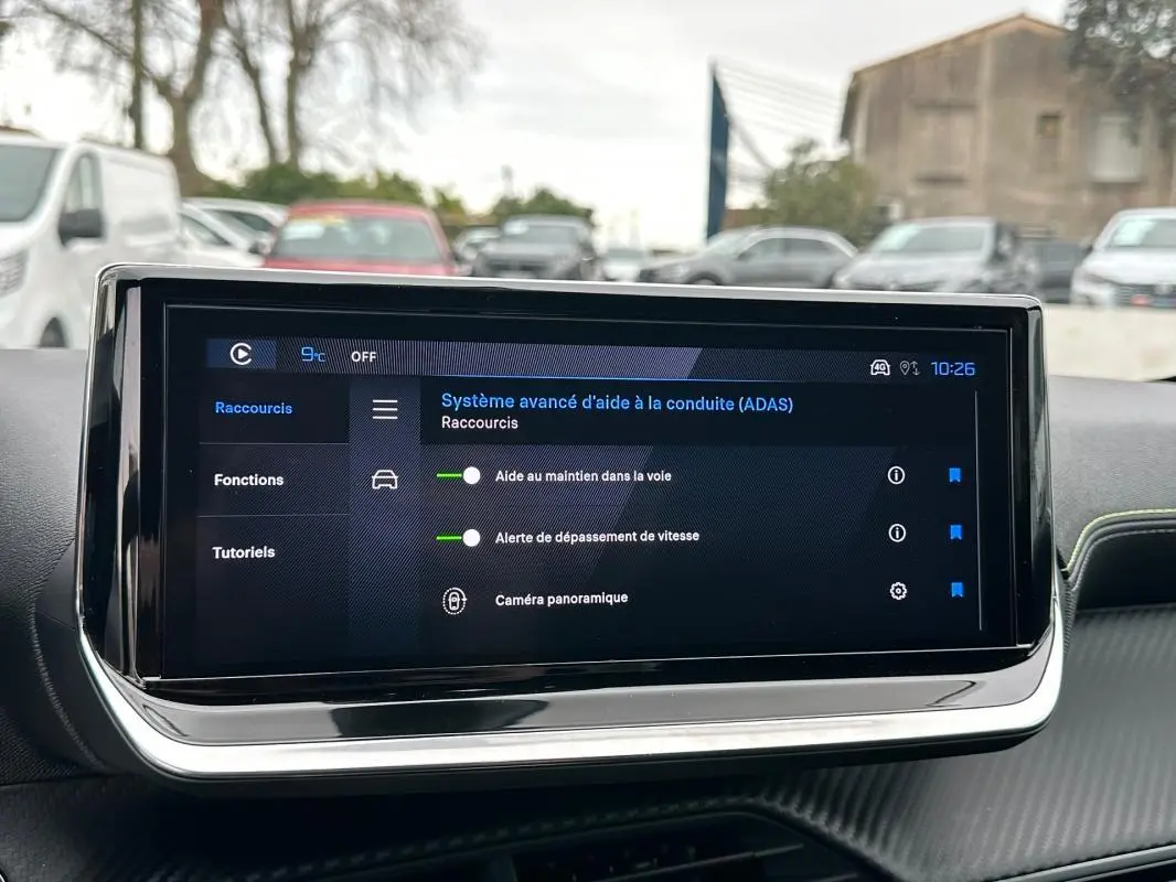 Écran tactile du tableau de bord du Peugeot 208 gris, affichant le système avancé d’aide à la conduite.