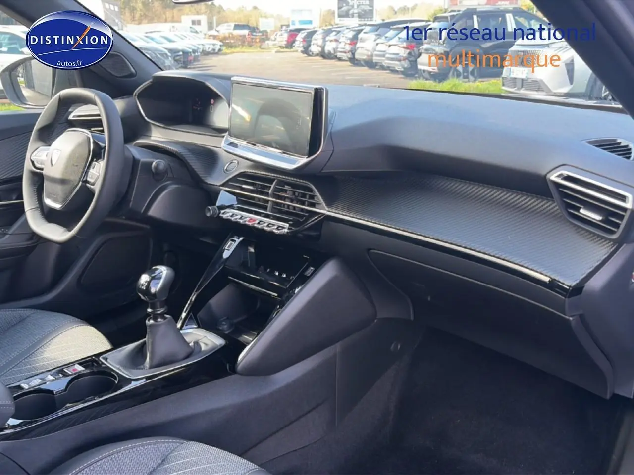 Intérieur avant droit du Peugeot 2008 1.2 100 Allure 2025 avec tableau de bord noir et écran tactile central.