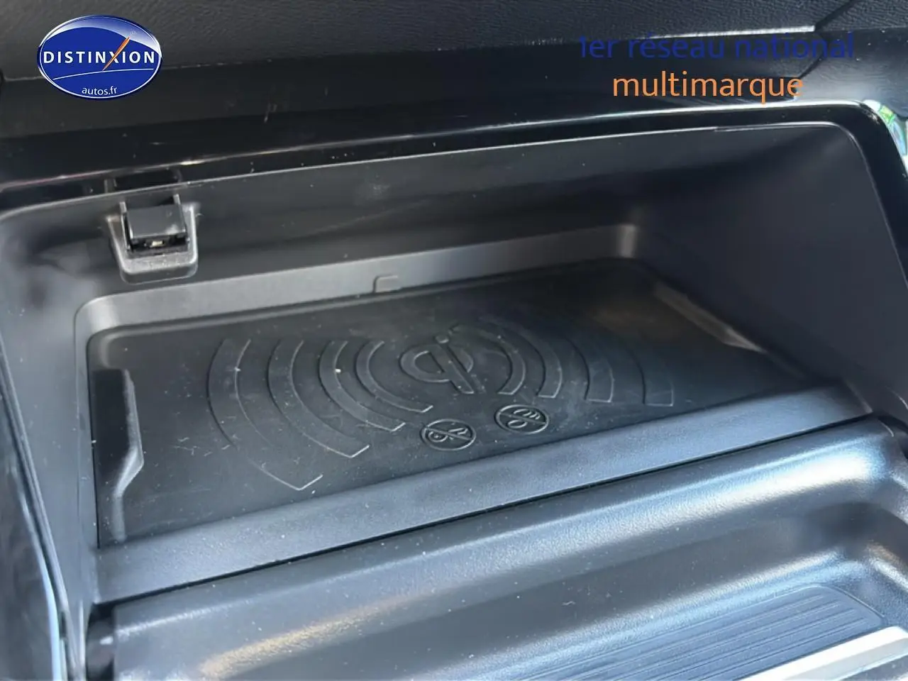 Gros plan sur le compartiment de recharge sans fil du Peugeot 2008 gris Artense, intérieur noir.