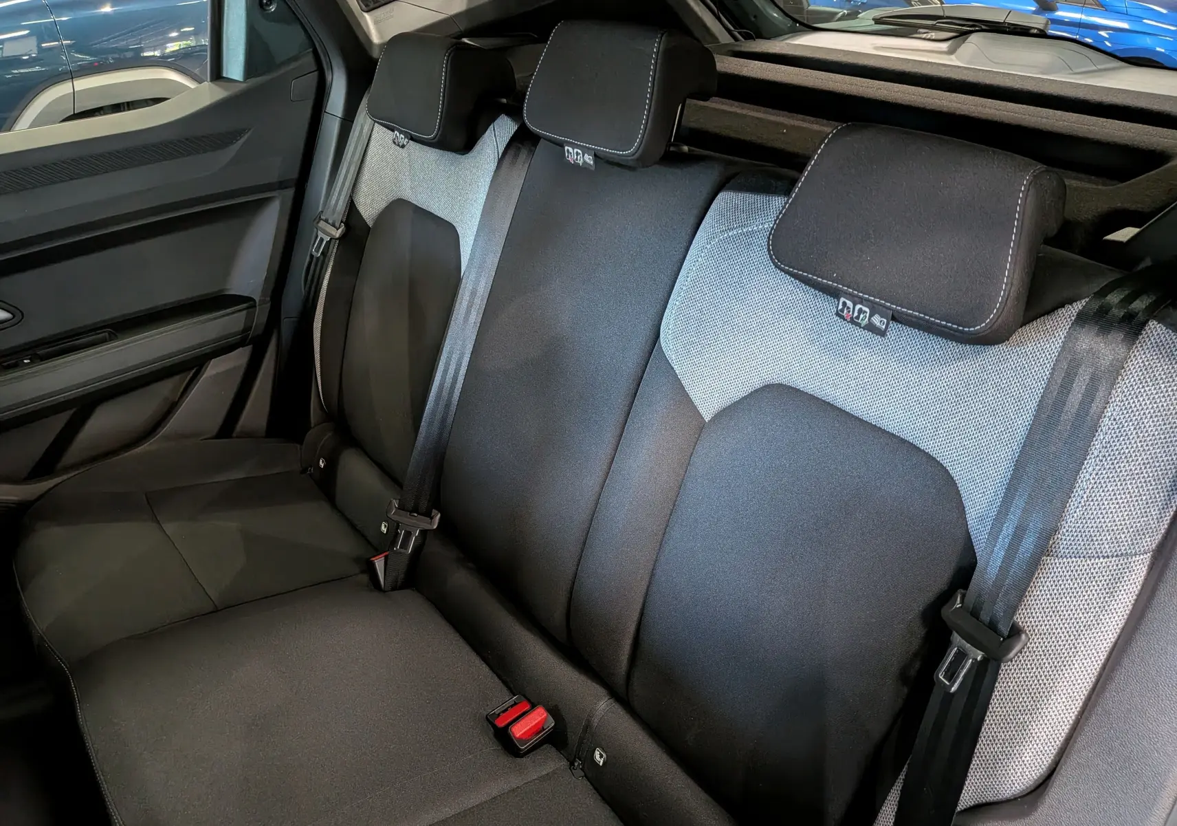 Vue intérieure des sièges arrière en tissu noir et gris du Dacia Duster Hybrid-G 150 CH 4x4, côté gauche visible.
