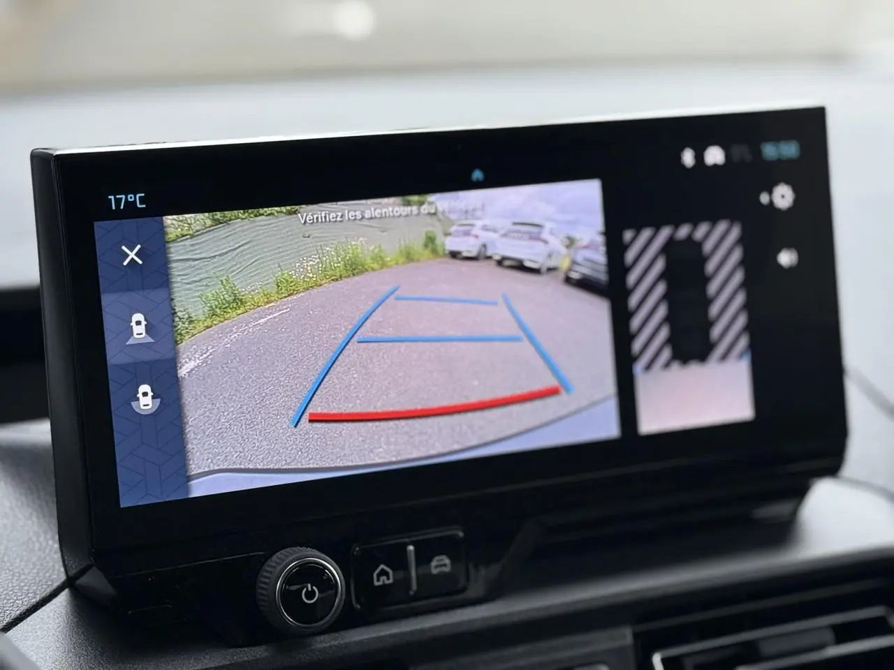 Écran tactile intérieur montrant la caméra de recul avec lignes de guidage du Citroën Berlingo gris acier.