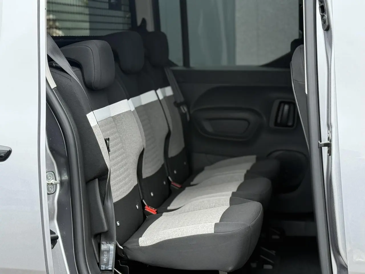 Vue latérale intérieure sur les trois sièges arrière indépendants gris clair et noir du Citroën Berlingo Multispace gris acier.