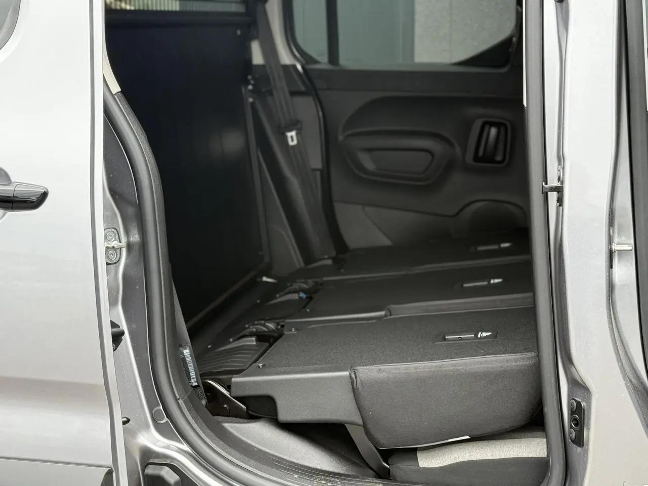 Vue latérale côté droit du Citroën Berlingo Multispace gris acier, sièges arrière escamotés et porte coulissante ouverte.