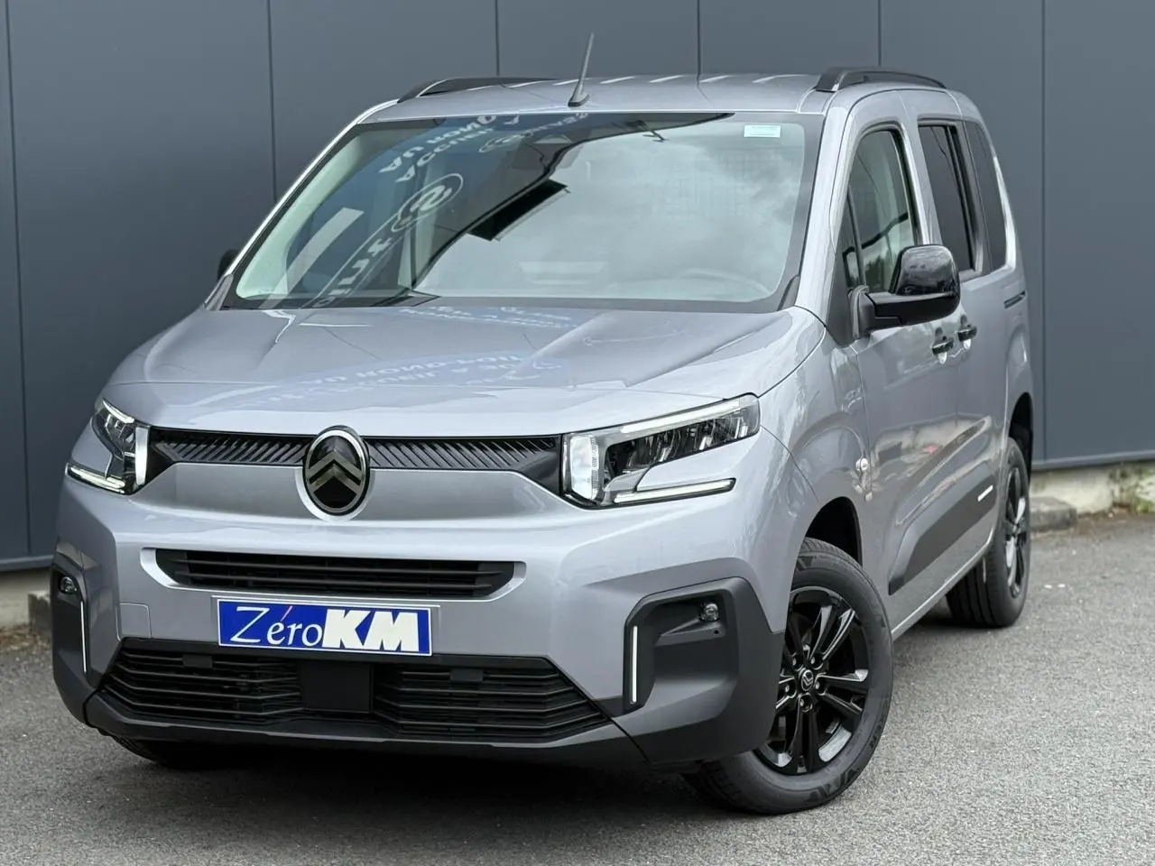 Citroën Berlingo Multispace gris acier en 3/4 avant droit avec jantes alliage noires et lunette arrière ouvrante.