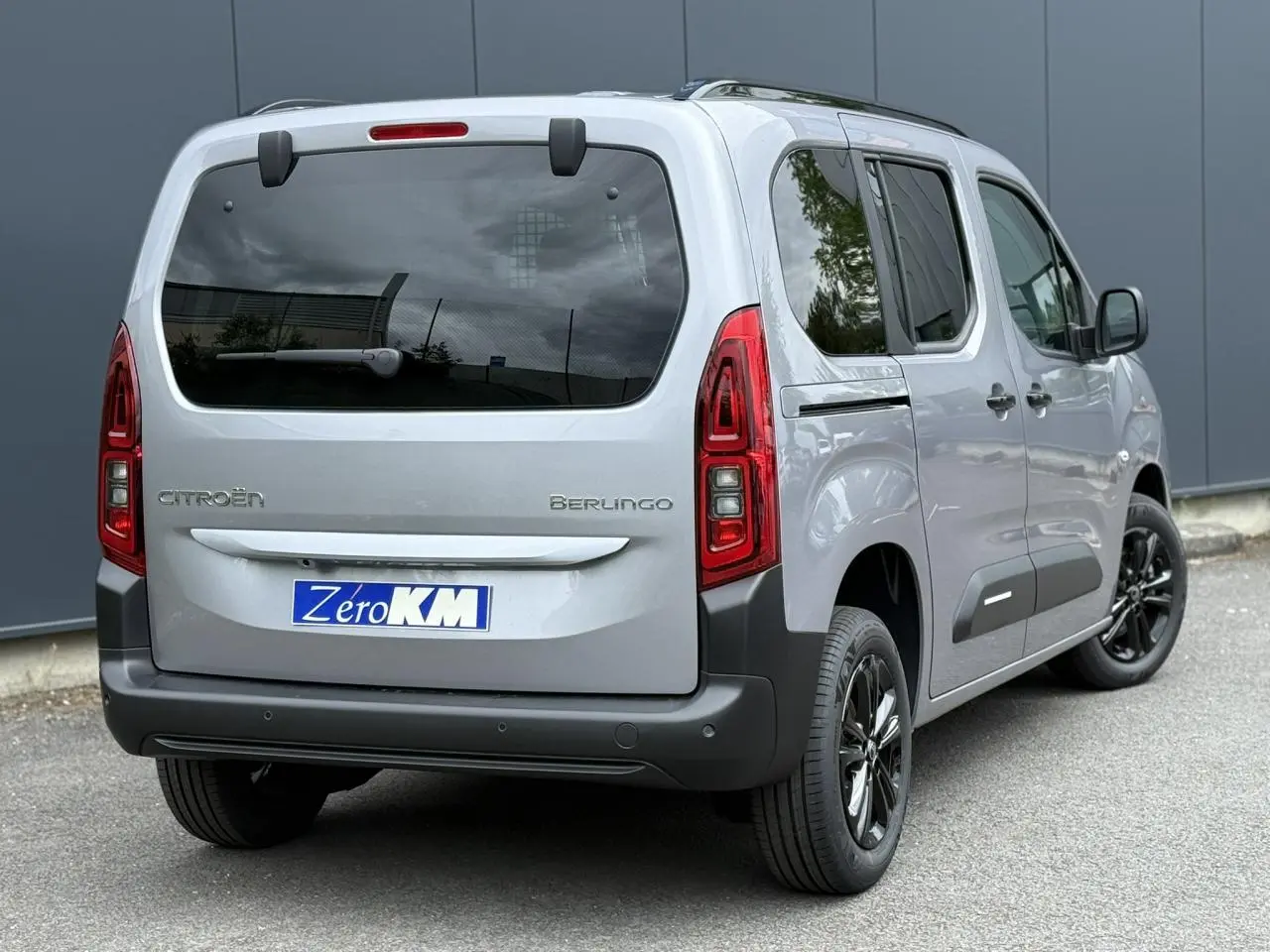 Vue 3/4 arrière droite d'un Citroën Berlingo Multispace gris acier avec lunette arrière ouvrante et jantes noires.