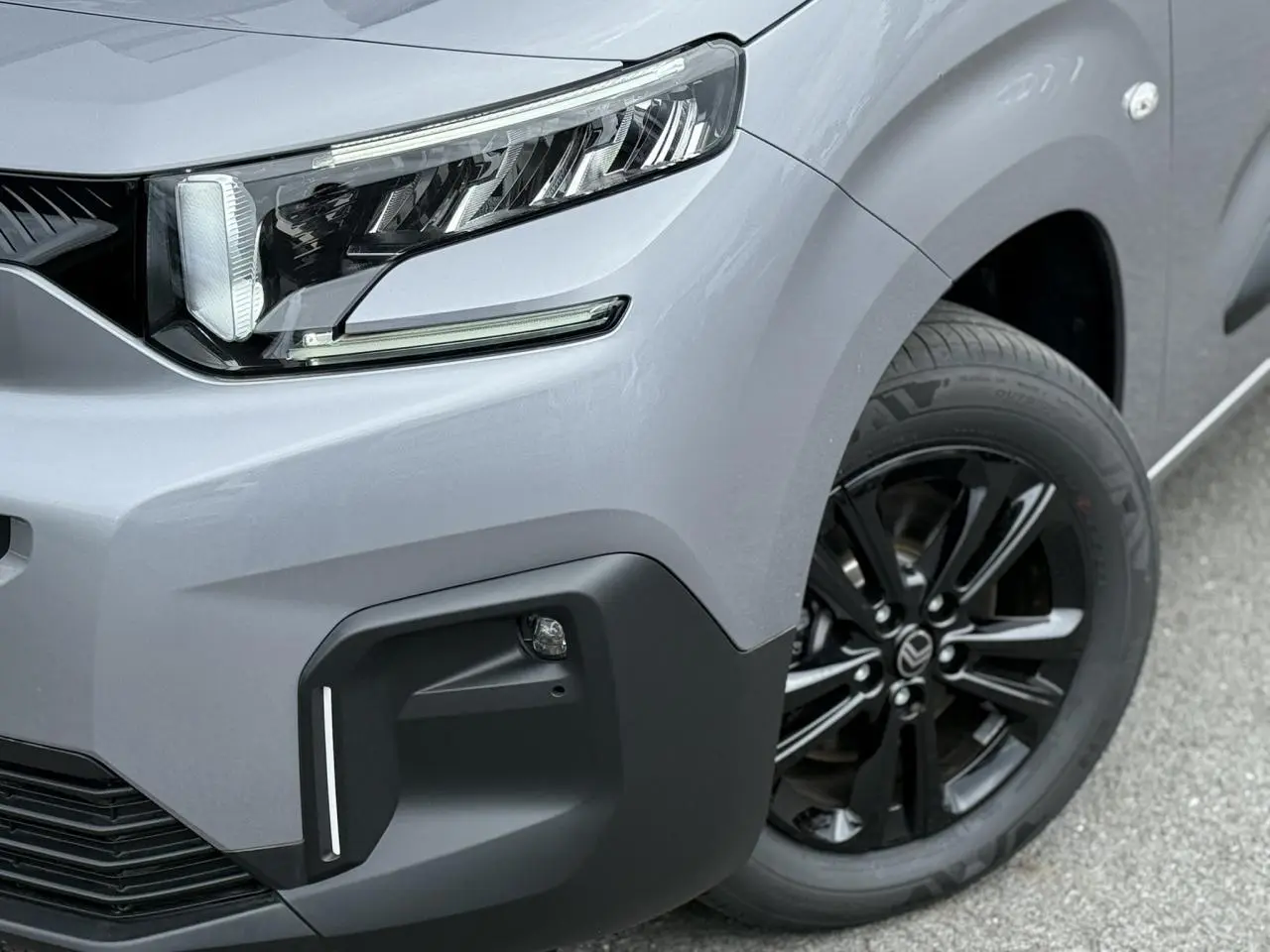 Gros plan sur l’avant droit du Citroën Berlingo gris acier 2026, avec phare LED et jante alliage noire.
