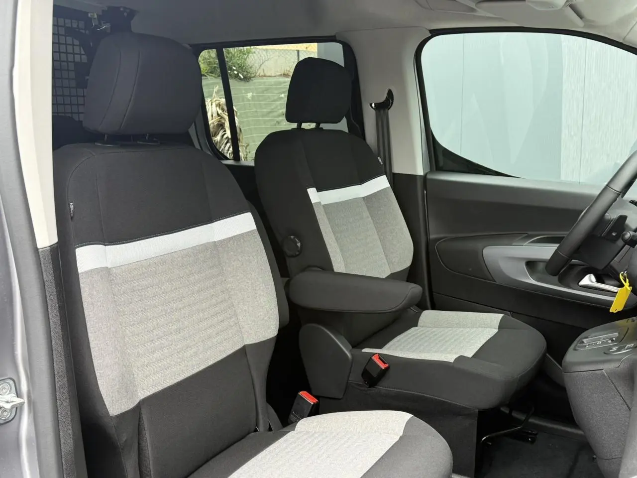 Vue intérieure côté conducteur du Citroën Berlingo Multispace gris acier, sièges bi-ton avec accoudoirs et volant multifonctions.