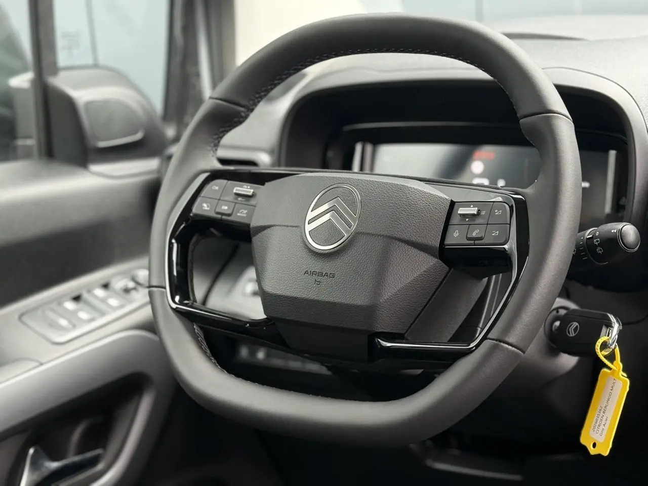 Vue rapprochée du volant multifonctions cuir noir de Citroën Berlingo Multispace 2026 avec logo chromé central.