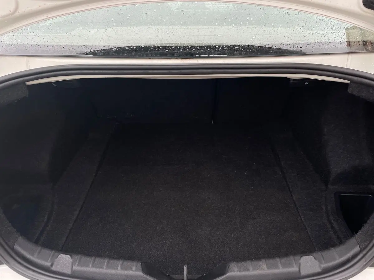 Coffre ouvert d'une BMW Série 2 Coupé F22 blanc de 2014, vue intérieure montrant un espace de rangement vide et propre.