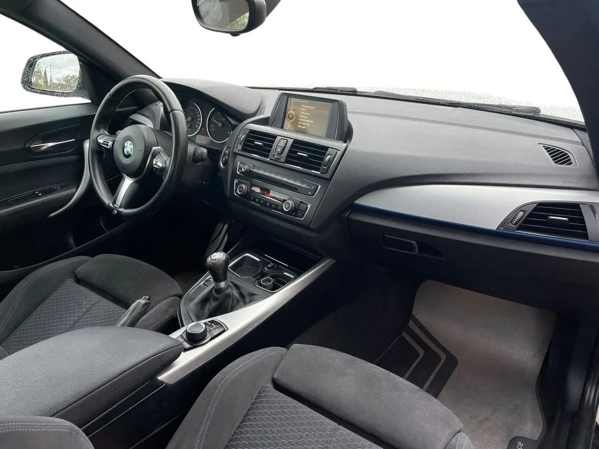 Intérieur noir de BMW Série 2 Coupé F22 220d M Sport 2014, vue côté conducteur avec boîte manuelle et tableau de bord moderne.
