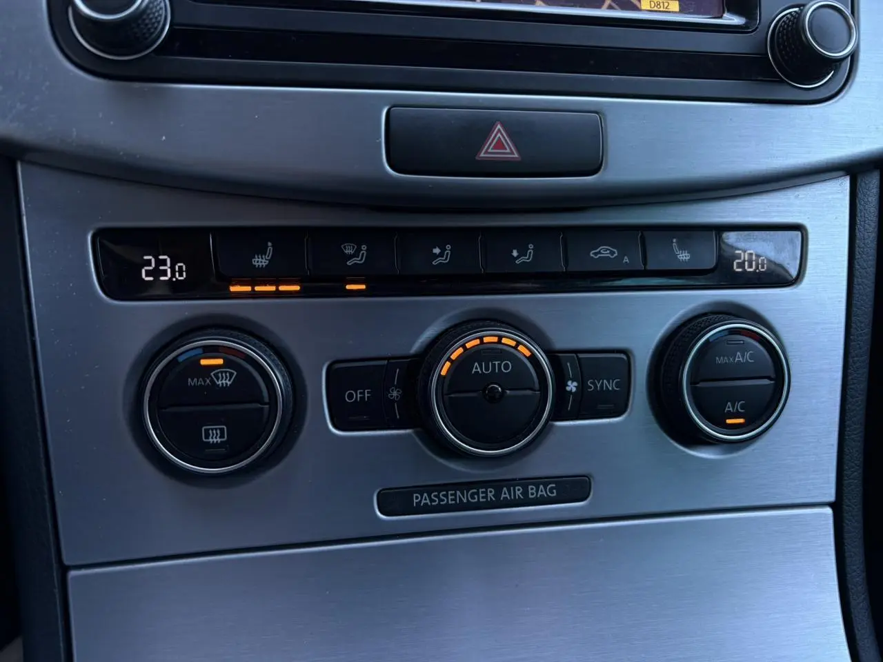 Gros plan sur la console centrale en finition aluminium brossé avec commandes de climatisation bi-zone de la Volkswagen Passat CC Deep Black.