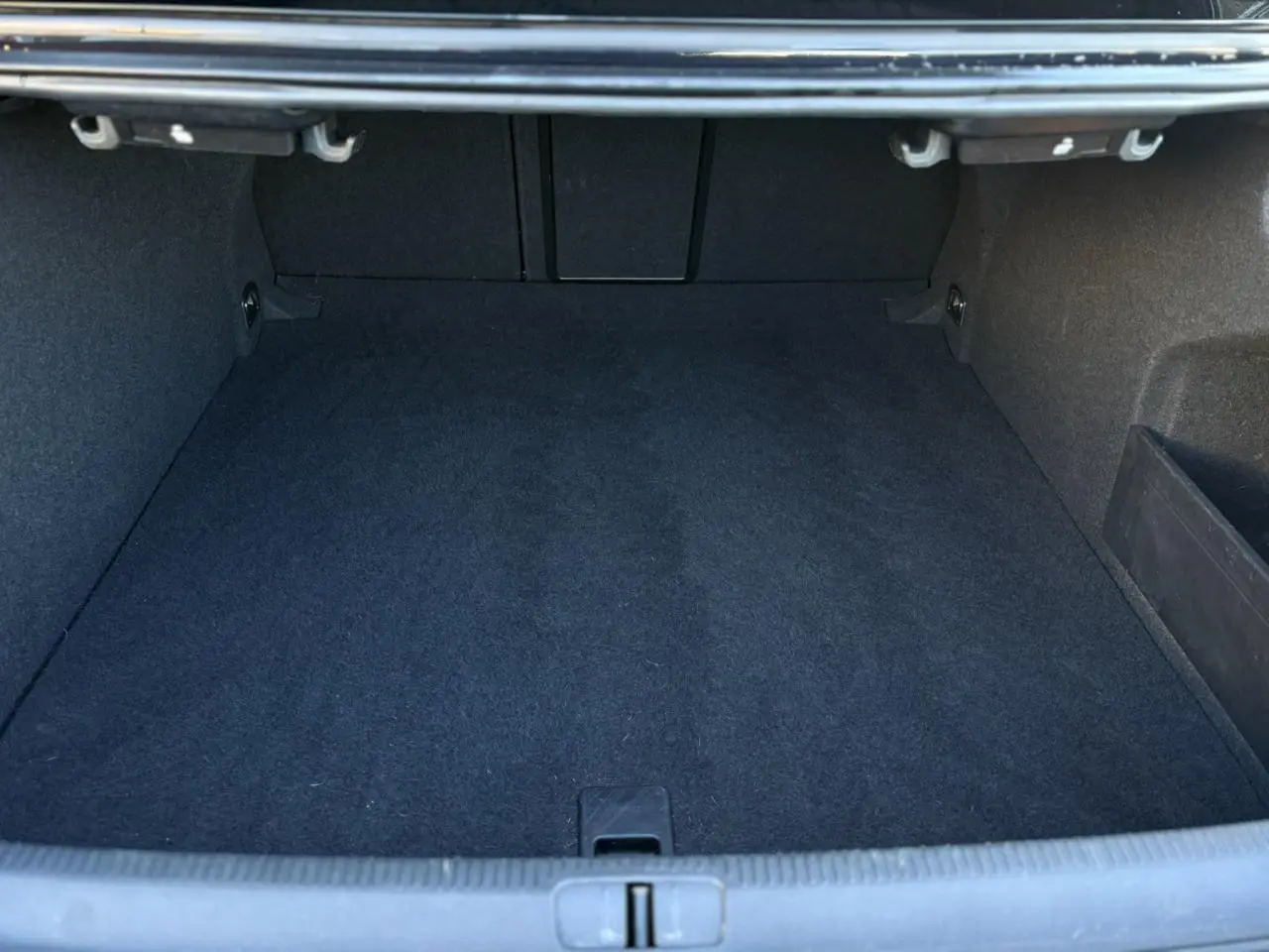 Coffre vide vu de face, intérieur noir profond, montrant l'espace de chargement du Volkswagen Passat CC 2015.