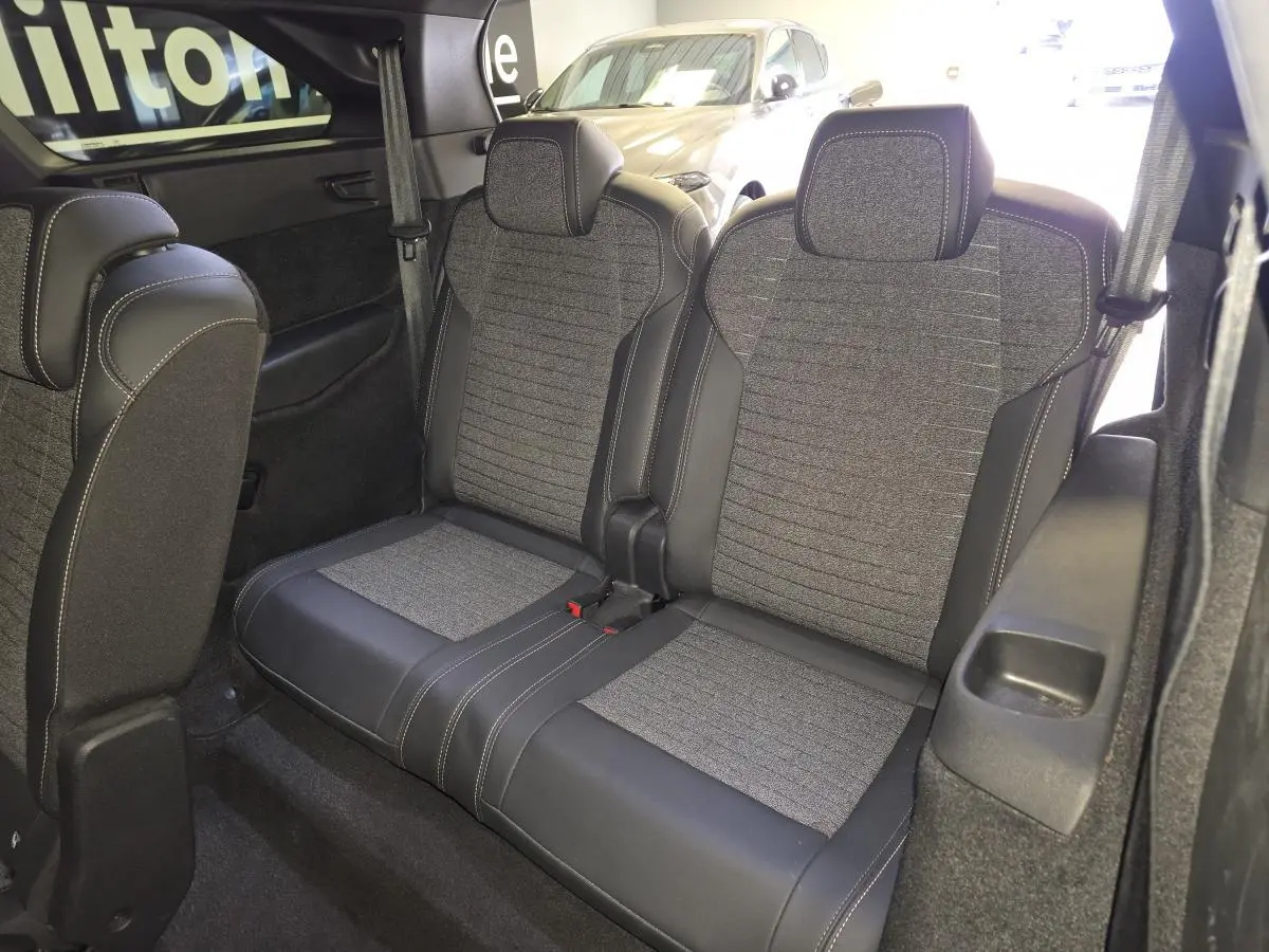 Vue intérieure sur la banquette 3e rangée tissu gris et cuir noir du Peugeot 5008 hybride 2025.