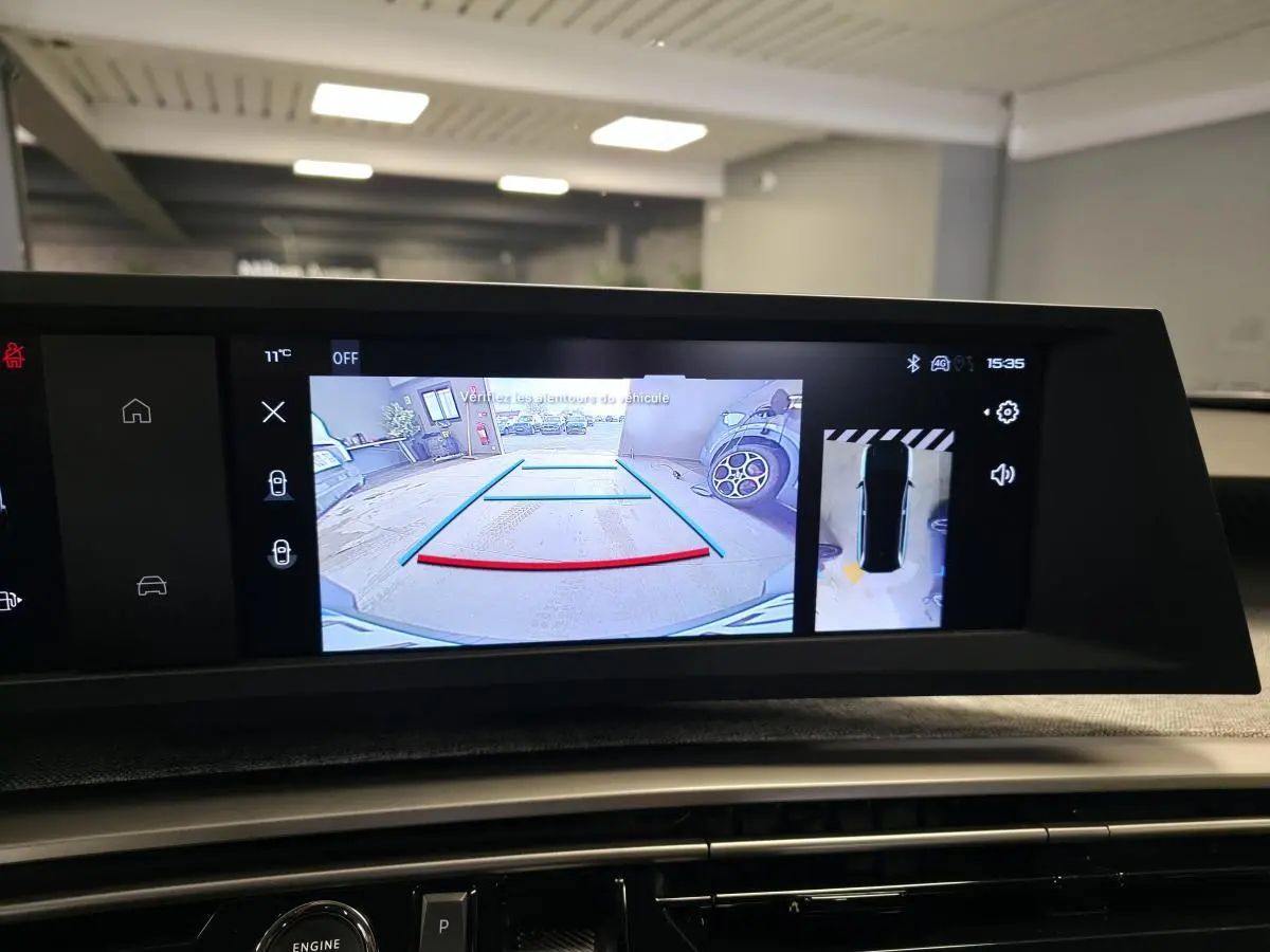 Écran intérieur affichant la caméra de recul et vue 360° du Peugeot 5008 gris, tableau de bord moderne.