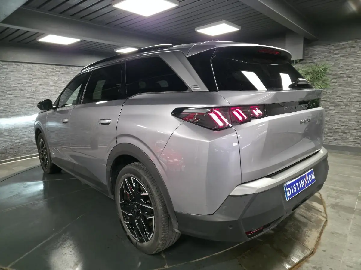 Vue 3/4 arrière droite du Peugeot 5008 gris métallisé avec feux arrière LED à 3 griffes et jantes alliage noires.